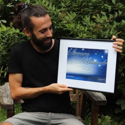 Mann mit Urkunde zur Sterntaufe Mann will Sterne kaufen